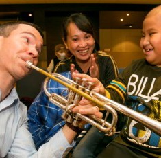 CSO-Principal-trumpet-Chris-Martin-lets-a-young-audience-member-play-a-tune-on-his-trumpet-credit-Todd-Rosenberg